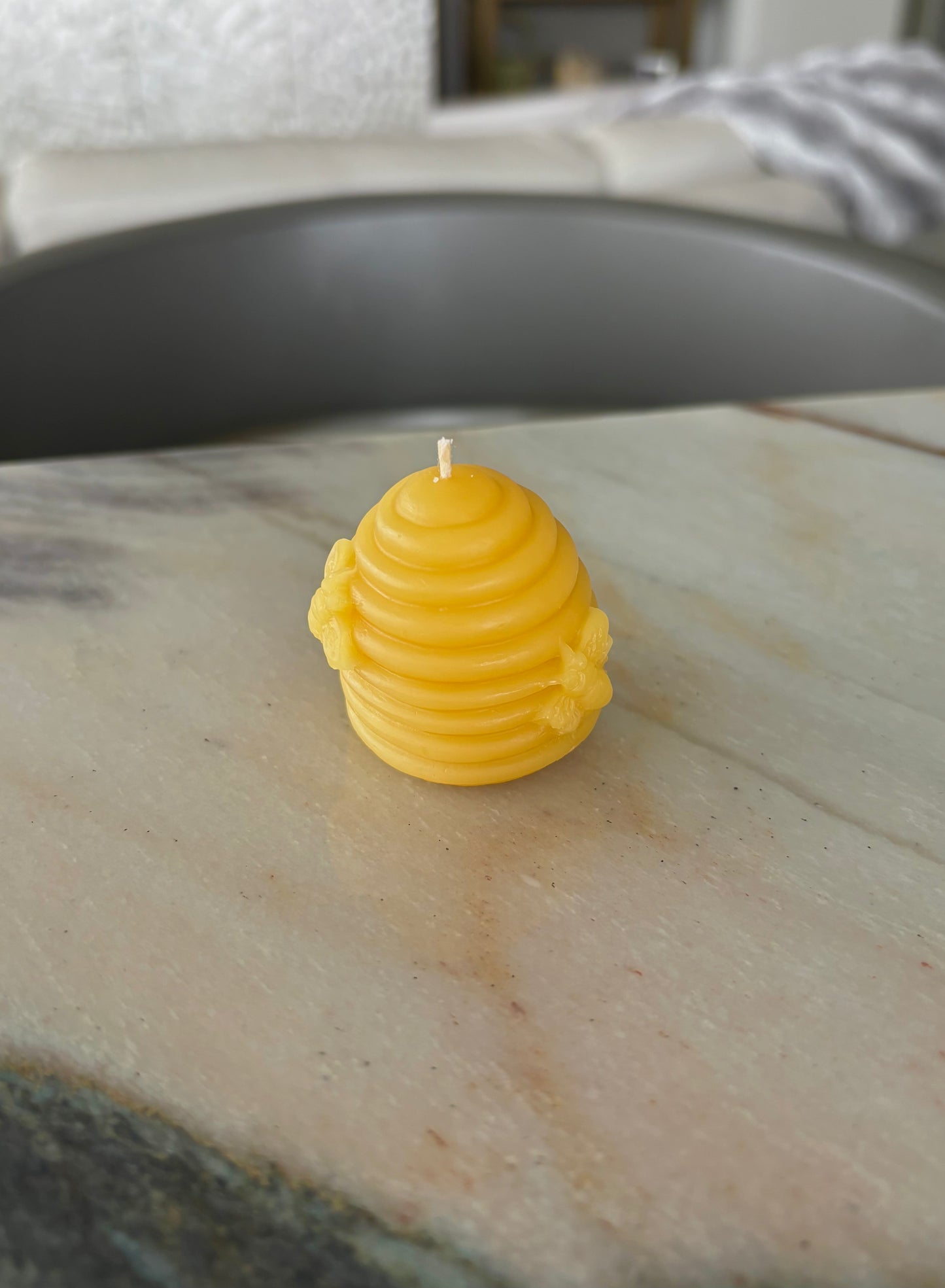 Natural beeswax beehive candle on a wooden surface, showcasing its eco-friendly design and warm glow.
